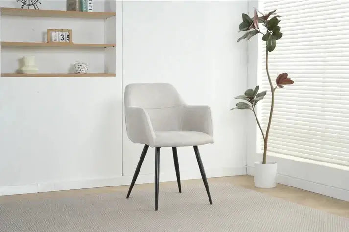 Alt Tag: Ruby Dining Chairs - Upholstered beige fabric dining chair with curved backrest and black legs in modern home setting